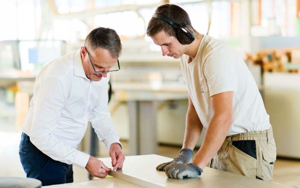 Moment de transmission des savoirs entre un industriel et un de ses jeunes ouvriers. Reportage photo industriel.