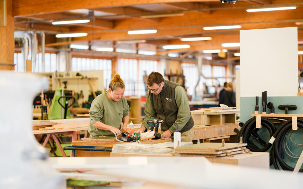 Deux ouvriers travaillant ensemble sur leur établi au sein de l'usine Roux Frères en Ardèche - Photographe industriel