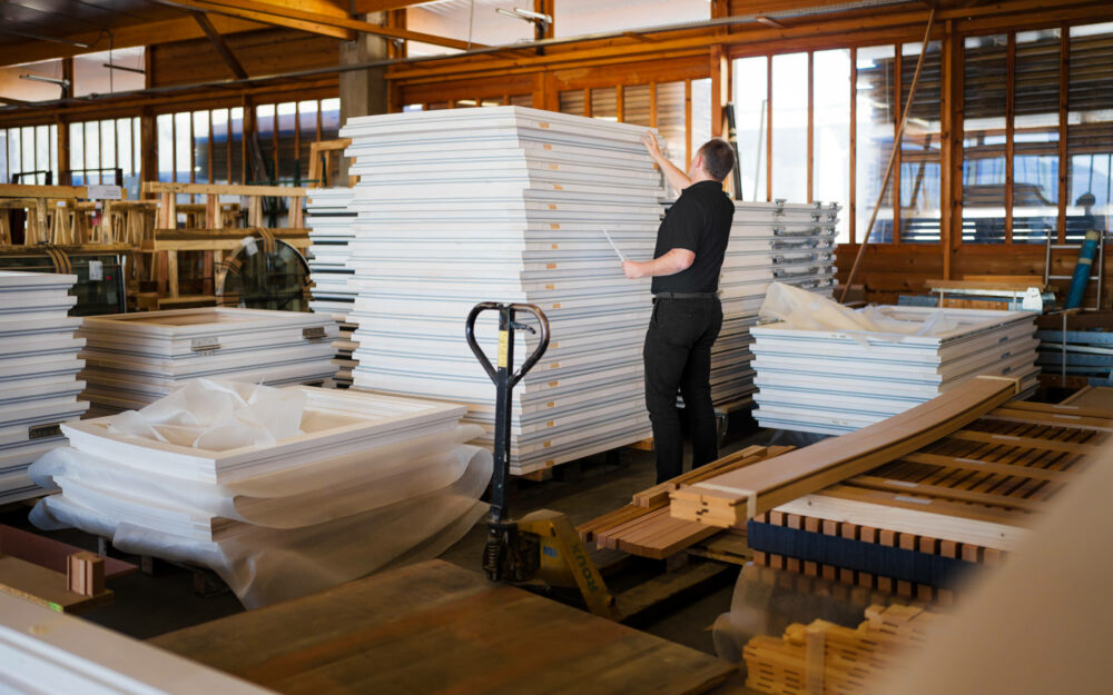 Ouvrier inspectant le stock de produits finis dans l'usine Roux Frères – Photographie de reportage industriel.
