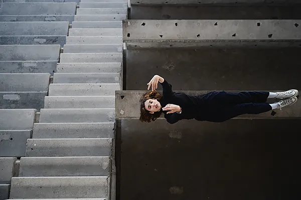 Danseuse dans un escalier en béton brut – Site Le Corbusier Firminy Danseuse dans un escalier en béton brut au stade du Site Le Corbusier Firminy, architecture moderne