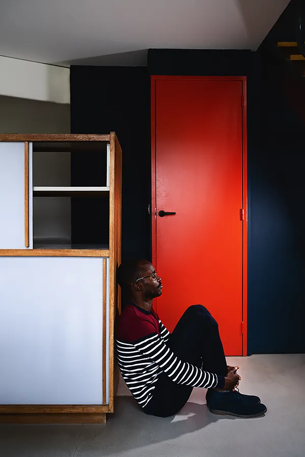 Porte rouge – Unité d’habitation, Site Le Corbusier de Firminy Personnage près d’une porte rouge dans l'unité d'habitation, Site Le Corbusier Firminy, photographie d’architecture