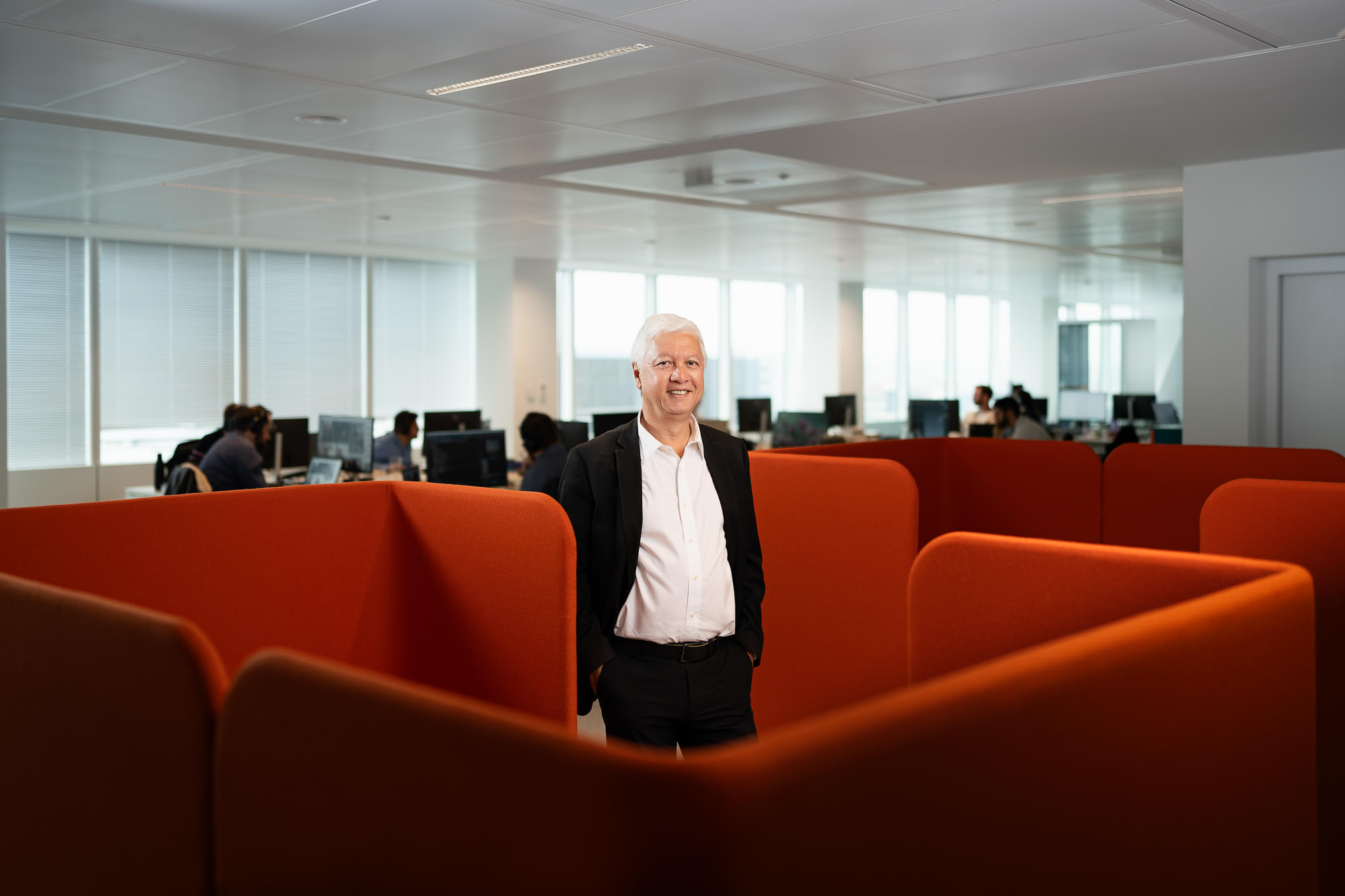 Portrait en entreprise à Lyon : homme en costume dans un open space de bureaux