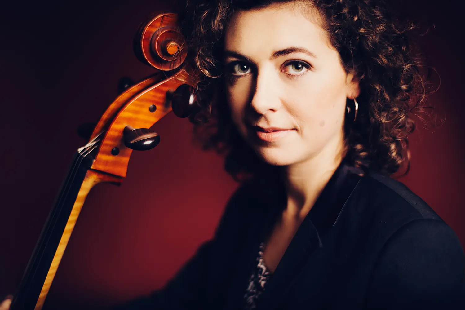 Portrait de la violoncelliste Lydie Lefebvre réalisé par le photographe Olivier Ramonteu. Portrait de musicienne en studio sur fond rouge.