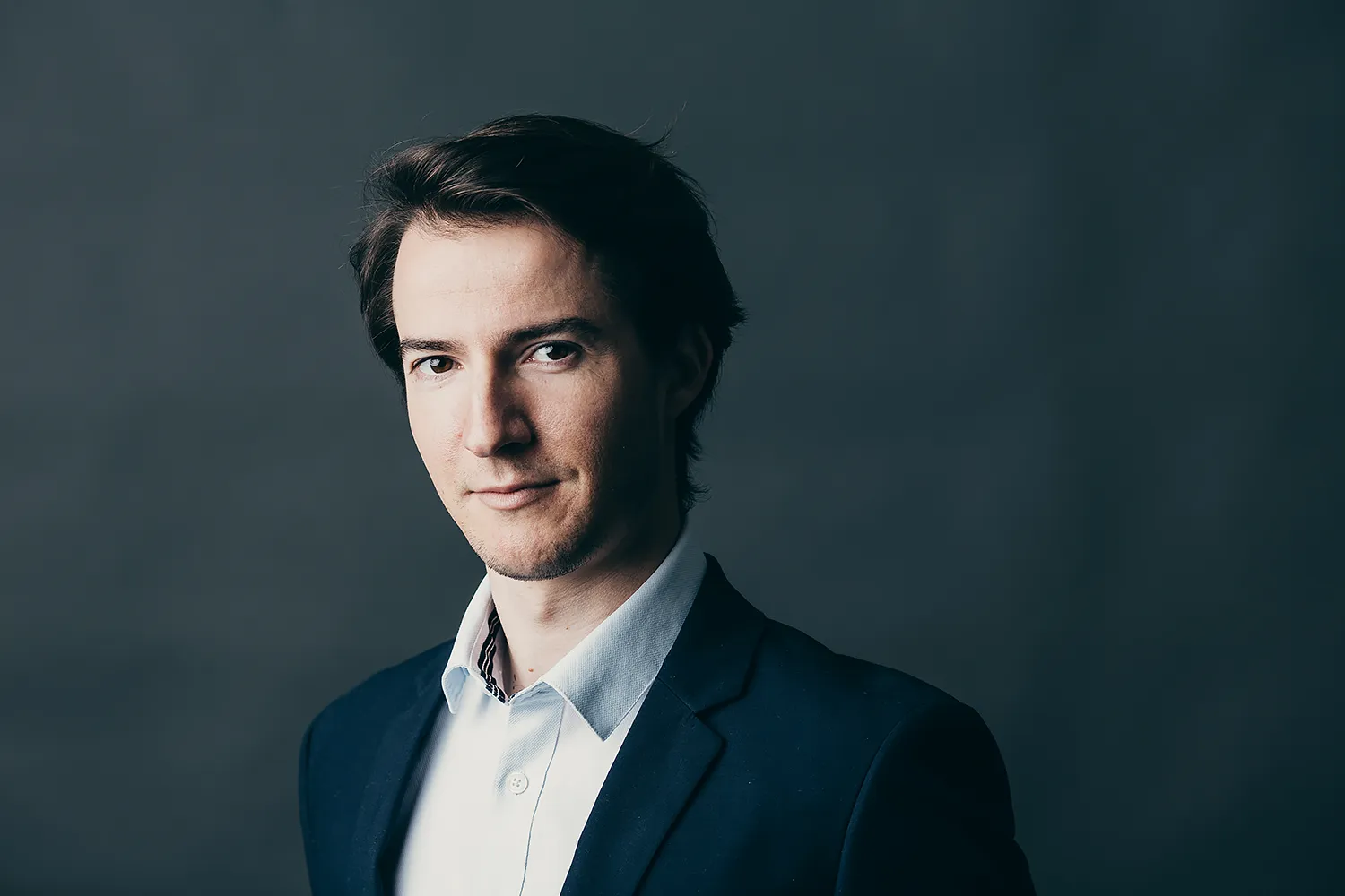 Portrait photographique. Ce portrait a été réalisé pour un usage professionnel par le photographe Olivier Ramonteu. C'est un portrait en studio sur fond gris foncé.