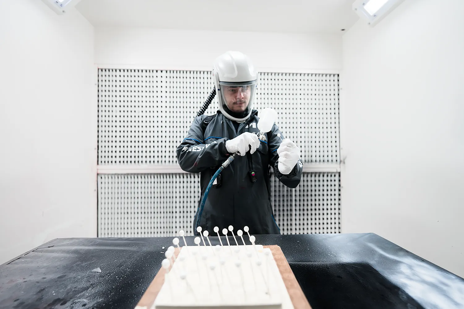 Portrait d’un opérateur de peinture industrielle à Paris Opérateur industriel en combinaison de sécurité appliquant de la peinture lors d'un reportage photographique professionnel à Paris.